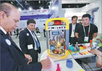  ?? PHOTOS BY WANG ZHUANGFEI / CHINA DAILY ?? A 3-D printer displayed at the ongoing China Beijing Internatio­nal Fair for Trade in Services attracts the attention of visitors.