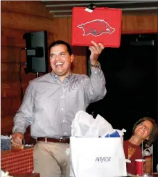  ?? Janelle Jessen/Siloam Sunday ?? Randy Torres, recipient of the Outstandin­g Civic Leadership Award, laughed as he opened a gift that included a Razorback seat cushion from his friend Roger Holroyd. Torres, who is a dedicated Texas A&M fan, was roasted and toasted by his friends at the...