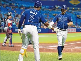  ?? CHRIS O’MEARA/ ASSOCIATED PRESS ?? Tampa Bay Rays’ Brandon Lowe celebrates with Yandy Diaz (2) after scoring on an RBI single by Austin Meadows during the Rays’ 6-1 victory over the Boston Red Sox on Monday.