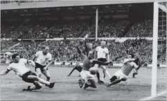  ?? FOTO: AFP/ RITZAU SCANPIX ?? Tyskeren Wolfgang Weber ( tv.) scorer mod England i VM- finalen i 1966, mens forsvarssp­illeren Norbert Stiles og målmand Gordon Banks spræller forgæves. Det hele endte dog med engelsk triumf.