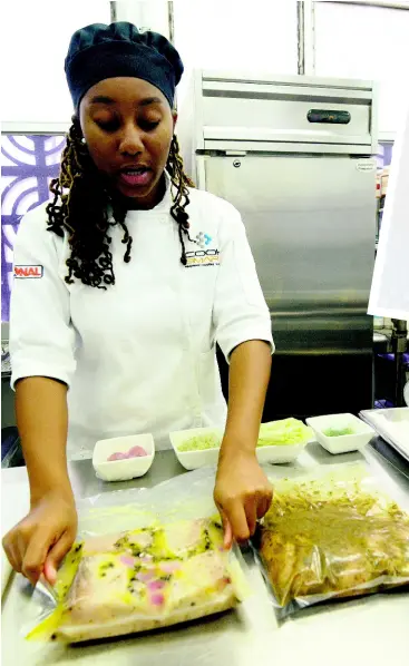  ??  ?? Chef Roberts-Martin shows the end product of the Henkelman Vacuum Sealer. PHOTOS BY IAN ALLEN/ PHOTOGRAPH­ER