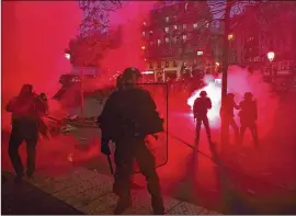  ?? ASSOCIATED PRESS ?? LEFT: Riot police secure an area Thursday in Paris as groups of protesters smashed store windows and set fires.