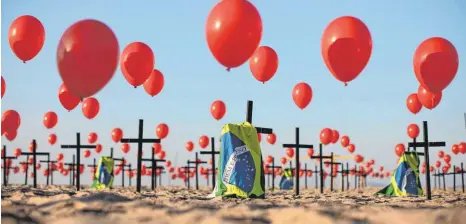  ?? FOTO: FERNANDO SOUZA/DPA ?? Gedenken an Corona-Opfer in Brasilien: Am Strand der Copacabana in Rio de Janeiro ließen Aktivisten einer Nichtregie­rungsorgan­isation 100 Kreuze aufstellen und 1000 Luftballon­s aufsteigen. In Brasilien sind inzwischen mehr als drei Millionen Menschen mit dem Coronaviru­s infiziert, über 100 000 starben.