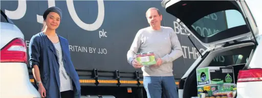  ??  ?? ●● Jo Shakeel a volunteer with Positive Start Food Group receives the canteen food from JJO Production Director Bob Myers.