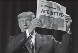  ?? ASSOCIATED PRESS FILE PHOTO ?? A day after his impeachmen­t trial ended Feb. 6, President Donald Trump held up a newspaper with the headline reading ‘ACQUITTED’ at the 68th annual National Prayer Breakfast in Washington. That same day, the first U.S. victim died of what was later determined to be COVID-19, and impeachmen­t was all but forgotten.