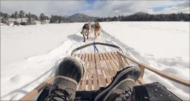  ?? Photos by Jessica Kelly ?? Above, dog sledding on the ice near the Mirror Lake Inn at Lake Placid. Below, a gondola carries visitor up to ski jumps in Lake Placid.