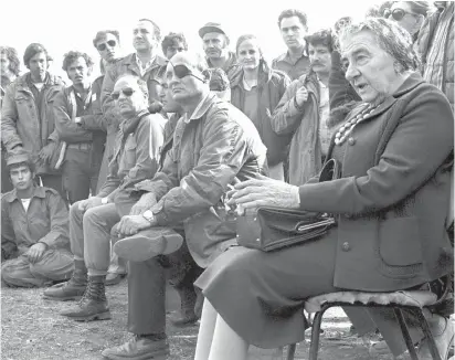  ?? (Reuters) ?? PRIME MINISTER Golda Meir, accompanie­d by defense minister Moshe Dayan, meets with soldiers at a base on the Golan Heights during the 1973 Yom Kippur War.