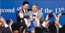  ?? FENG YONGBIN / CHINA DAILY ?? People’s Bank of China Governor Yi Gang (center) interacts with reporters after a news conference in Beijing on Sunday as Vice-Governor Chen Yulu passes nearby.