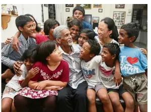  ??  ?? Sharing the Christmas joy: David with the children at his home in Reservoir Garden, Ayer Itam in Penang.