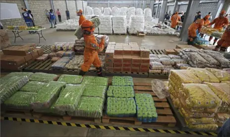  ?? Fernando Vergara/Associated Press ?? Venezuelan volunteers, Colombian firefighte­rs and rescue workers prepare USAID humanitari­an aid for storage Friday at a warehouse next to the Tienditas Internatio­nal Bridge, near Cucuta, Colombia, on the border with Venezuela.