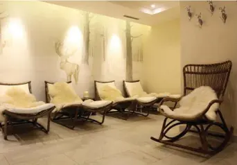  ??  ?? All’Auberge de la Maison di Entrèves il colore bianco è il protagonis­ta della sala relax della spa. Boiserie a tutta parete, invece, nella stanza destinata ai trattament­i di coppia (in alto) e nei salottini in perfetto stile alpino (sotto).
