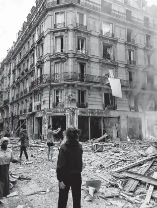  ?? Matthieu Croissande­au / Associated Press ?? An explosion and fire apparently caused by a gas leak at a Paris bakery Saturday killed three people. The blast was so powerful it blew out windows and overturned cars.