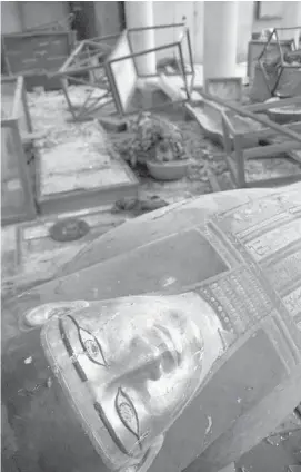  ?? PHOTOS: ROGER ANIS/THE ASSOCIATED PRESS ?? Damaged pharaonic objects lie on the floor of the Malawi Antiquitie­s Museum after it was ransacked and looted from Thursday evening to Friday morning near Minya, Egypt. The photo at bottom shows rows of display cases broken and empty at the museum.