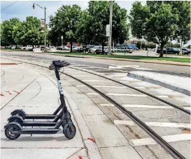  ?? [PHOTO BY CHRIS LANDSBERGE­R, THE OKLAHOMAN] ?? Bird.co’s rental scooters were “nested” along the streetcar tracks in Bricktown on Tuesday. The city council gave Bird.co until Monday to get a permit to park scooters on public rights of way.