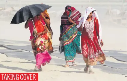  ?? Picture: Reuters ?? Women make their way along the banks of the river Ganges during a dust storm in Allahabad, India.