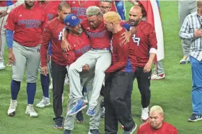  ?? ERIC ESPADA/GETTY IMAGES ?? Edwin Diaz is helped off the field after being injured during the celebratio­n after Puerto Rico defeated the Dominican Republic.