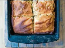  ??  ?? A pan full of spanakopit­a, the Greek phyllo pie made with a Southern twist: collard greens and kale have been substitute­d for the spinach.