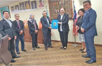  ?? ?? Liew (third right) receives a book on Sabah Parks from Maklarin during the courtesy visit.