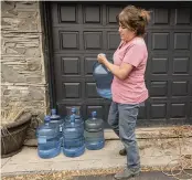  ?? NATHAN HOWARD AP ?? Misty Buckley moves containers of drinking water in Klamath Falls, Oregon, after the family’s well ran dry in May following an historic drought in southern Oregon.