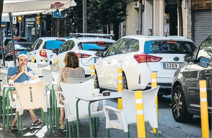  ?? MONTSE GIRALT ?? Distancia social. Terraza de la calle Marià Cubí, ejemplo de la escasa distancia entre el ocio y un tráfico condenado a empeorar por las nuevas limitacion­es