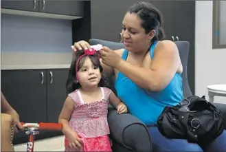  ?? Photog r aphs by
Katie Falkenberg
Los Angeles Times ?? MIRNA NAVARRO, with daughter Camila Gonzalez, has an apartment now but lived at the old shelter during last year’s f ire. “A shelter’s not as bad as you think,” she assures those in need.