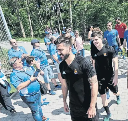  ?? FOTO: UNANUE ?? Los jugadores de la Real recibieron el apoyo de los miembros de la peña Bizkaia Txuri Urdin en el entrenamie­nto de ayer