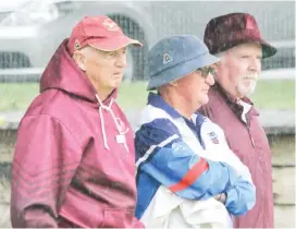  ??  ?? Taking shelter from the wind as they watch the action unfold in the division one contest at Drouin are (from left) Graeme Aubrey of Drouin, Jeff Wetzel of Newborough and Arthur Moore of Drouin.