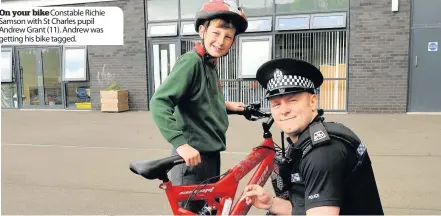  ??  ?? On your bike Constable Richie Samson with St Charles pupil Andrew Grant (11). Andrew was getting his bike tagged.