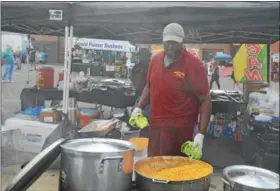  ?? NICHOLAS BUONANNO — NBUONANNO@TROYRECORD.COM ?? Mikey Watson of Reggae Boy Cafe prepares some food.