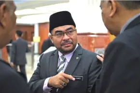  ??  ?? Mujahid talking to his officer at the Parliament lobby. — Bernama photo