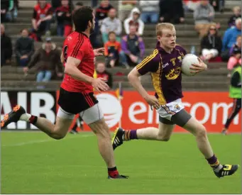 ??  ?? Wexford defender Simon Donohoe breaking away from Down’s Kevin McKernan.