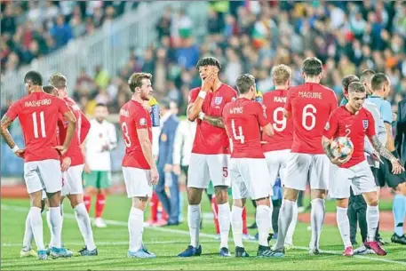  ?? STRINGER/AFP ?? The England players wait on the pitch during a temporary interrupti­on of the Euro 2020 Group A football qualificat­ion match between Bulgaria and England due to incidents with fans, at the Vasil Levski National Stadium in Sofia on Monday.