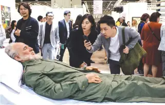  ??  ?? VISITORS TAKE photos of Chinese artist Shen Shaomin’s Fidel Castro, part of his “Summit” project, at Art Basel in Hong Kong on March 21.