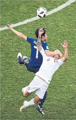  ?? NICOLAS ASFOURI/AFP/GETTY IMAGES ?? Japan midfielder Gaku Shibasaki, left, and Poland midfielder Jacek Goralski contest a ball in the air on Thursday. Late in the match Japan was more focused on avoiding yellow cards than on scoring.