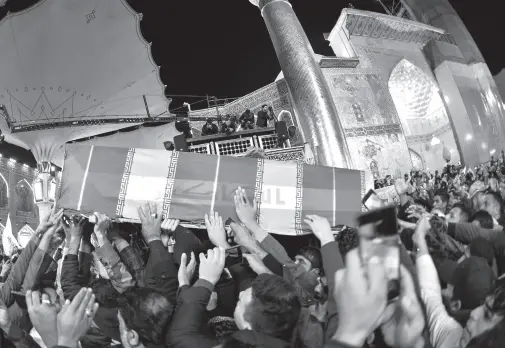  ??  ?? MOURNERS carry the coffins of slain Iraqi paramilita­ry chief Abu Mahdi al-Muhandis, Iranian military commander Qasem Soleimani and eight others towards the Imam Ali Shrine in the shrine city of Najaf in central Iraq during a funeral procession. Thousands of Iraqis chanted “Death to America” today as they mourned the deaths of al-Muhandis and Soleimani, who were killed in a US drone attack that sparked fears of a regional proxy war between Washington and Tehran. AFP PHOTO