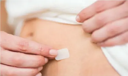  ?? Photograph: Phanie/Alamy ?? A woman applying an HRT patch. Researcher­s do not know for certain what biological mechanism might result in sexual activity influencin­g the onset of menopause.