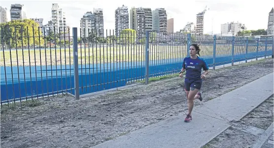  ?? Santiago filipuzzi ?? Una deportista amateur corre por el perímetro del Parque Chacabuco mientras aguarda la pista sintética