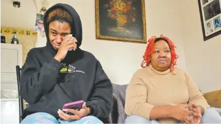  ?? STAFF PHOTO BY TIM BARBER ?? Akeiba Porter, left, the sister of shooting victim Sharone Porter, 22, wipes tears as Sytira Porter talks about her adopted son in her East Lake home Tuesday.