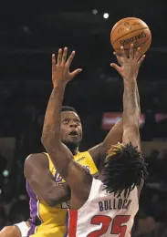  ?? Kyusung Gong / Associated Press ?? Julius Randle of the Lakers shoots over tight defense from Detroit’s Reggie Bullock.