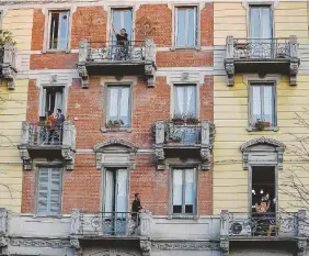  ?? LaPresse ?? Sul balcone Cittadini intonano canzoni alla finestre durante la “reclusione” da Covid-19