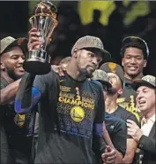  ?? Gregory Shamus Getty Images ?? KEVIN DURANT appears a bit underwhelm­ed with his second consecutiv­e trophy for Finals MVP.