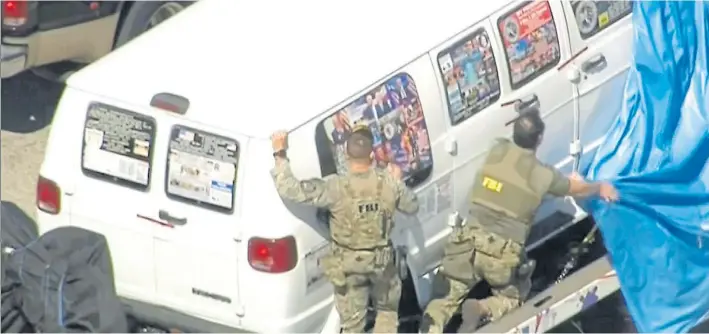  ?? AP ?? Evidencias. Agentes del FBI tapan la camioneta en la que fue detenido el sospechoso, en Florida. Las ventanilla­s están cubiertas de calcomanía­s de apoyo a Donald Trump.