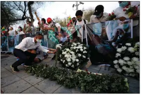  ?? (AP/Sakchai Lalit) ?? Burmese citizens living in Thailand lay flowers Thursday at the United Nations building in Bangkok in memory of the people who died in protests against Burma’s military coup.