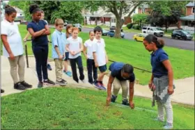  ?? MICHILEA PATTERSON — DIGITAL FIRST MEDIA ?? A group of fourth-graders measure how cloudy or clear water is outside Rupert Elementary School in Pottstown. The children attended an announceme­nt about a PECO grant making it possible for more students to learn through outdoor education.