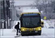  ?? LM OTERO — THE ASSOCIATED PRESS ?? A rider steps onto a bus during a light freezing rain in Dallas on Thursday. A major winter storm with millions of Americans in its path is spreading rain, freezing rain and heavy snow farther across the country.