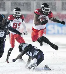  ??  ?? Calgary’s Jerome Messam jumps over Toronto Argonauts defensive back Cassius Vaughn on Sunday in Ottawa. The Stampeders running back had two touchdowns in his team’s 27-24 Grey Cup loss.
