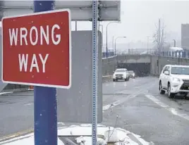  ?? STEVEN SENNE/AP ?? A“Wrong“Way”sign warns drivers from entering westbound on an eastbound exit ramp from the Massachuse­tts Turnpike, Route I-90, last month in Boston.