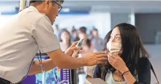  ?? CHOE JAE KOO/ AP ?? A quarantine officer at the Incheon Internatio­nal Airport in South Korea checks a traveler against possible infection of Ebola in 2014.