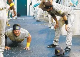  ?? ?? Luke Voit, who drove in three runs with a double in the third and a hit by pitch in the 10th, does pushups under the watch of Austin Nola after scoring in the third.