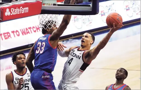  ?? David Butler II / Associated Press ?? UConn guard Tyrese Martin shoots against DePaul forward Pauly Paulicap during Wednesday’s game. Martin, a transfer from Rhode Island, contribute­d 22 points and 10 rebounds.
